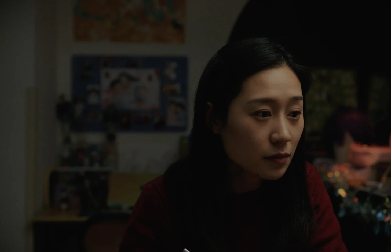 A woman in a red sweater looks toward someone beside the birthday table.